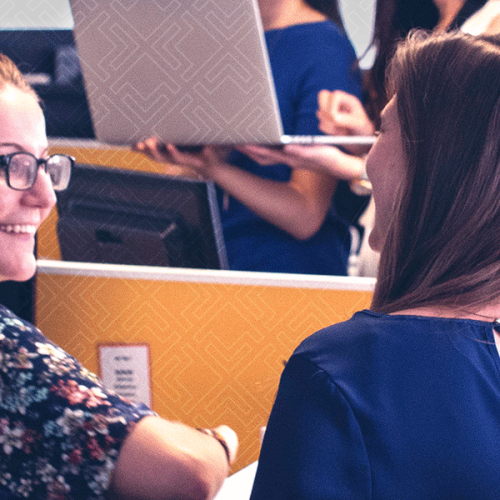 two women talking at a desk