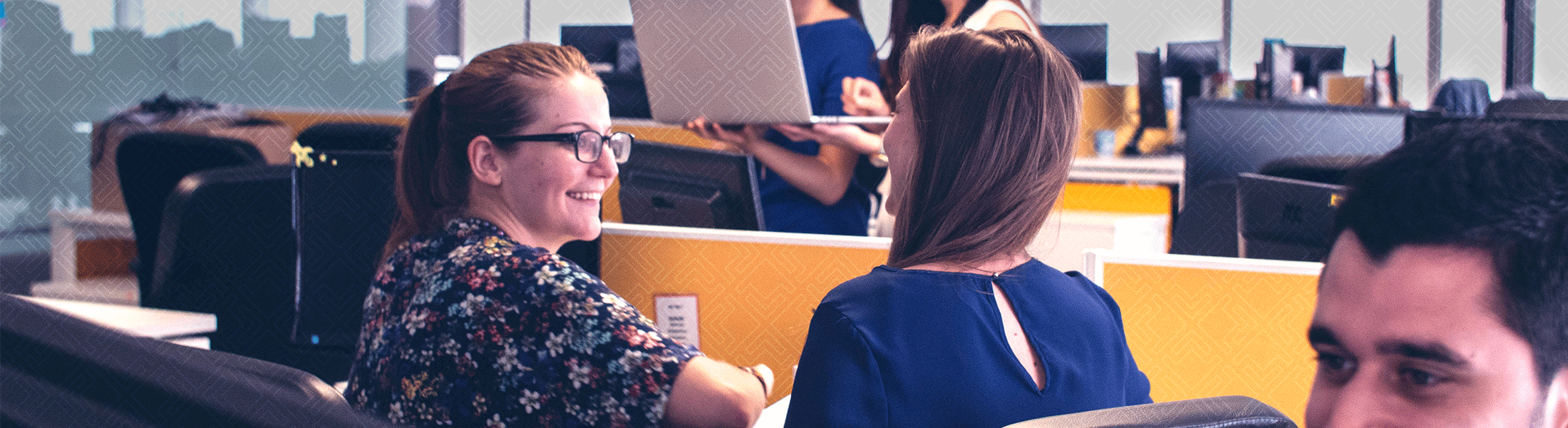 two women talking at a desk