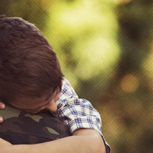 Army man hugging child