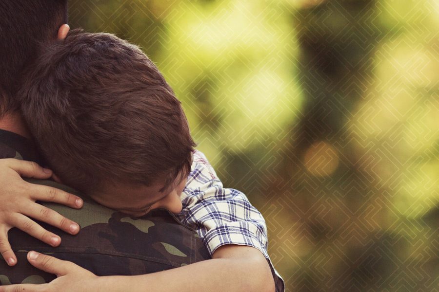Army man hugging child