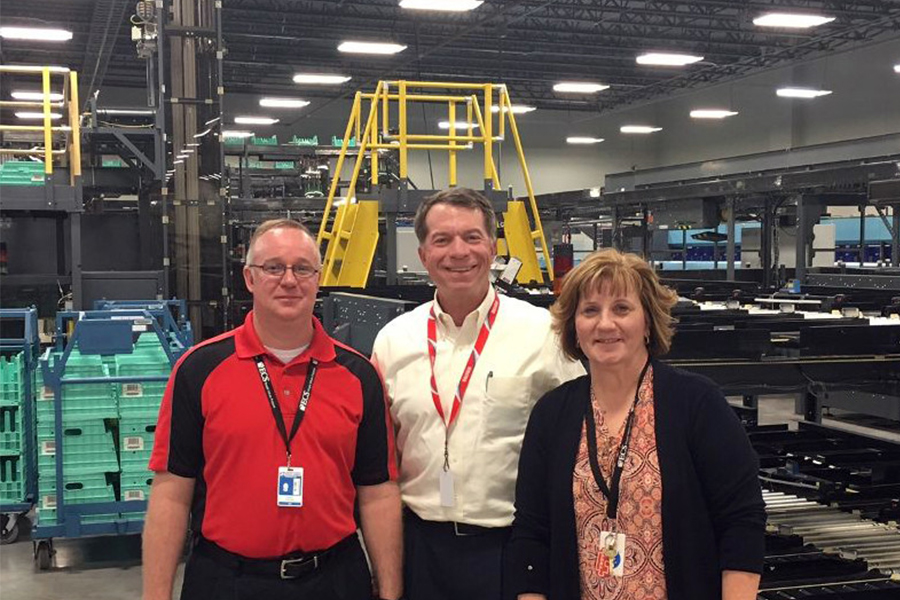George Wilson in a factory with employees