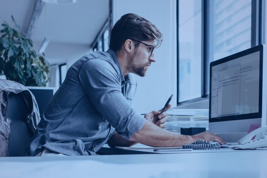 Man at a desk looking at a computer